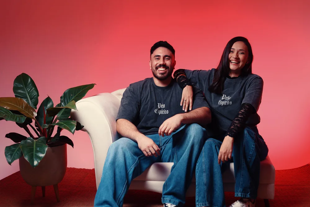 Casal sentado no sofá vestindo a camiseta preta estonada